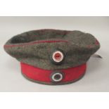 A German World War I pork-pie cap with a maroon band and piping (Please Note: this lot is subject to