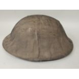 A British World War I military tin hat with a stitched cloth cover, liner and hide chin strap (