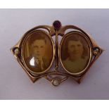 An Art Nouveau gold coloured metal locket brooch, the framed set with two coloured stones and a pair