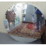 A modern unframed mirror with a multi-sectional plate  40"dia