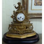 An early 20thC (probably French) gilt metal mantel clock, fashioned as a figure wearing period