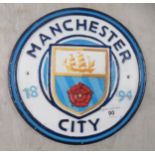 A cast and painted metal sign 'Manchester City'  9"dia