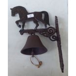 A cast metal wall mounted doorbell, surmounted by a horse  15"h