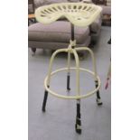 A cream painted cast metal tractor seat design bar stool