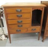 An Edwardian mahogany sheet music cabinet with six drawers and an open section, raised on square,