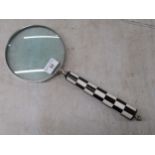 A silver plated 'giant' magnifying glass, on a black and white chequered handle