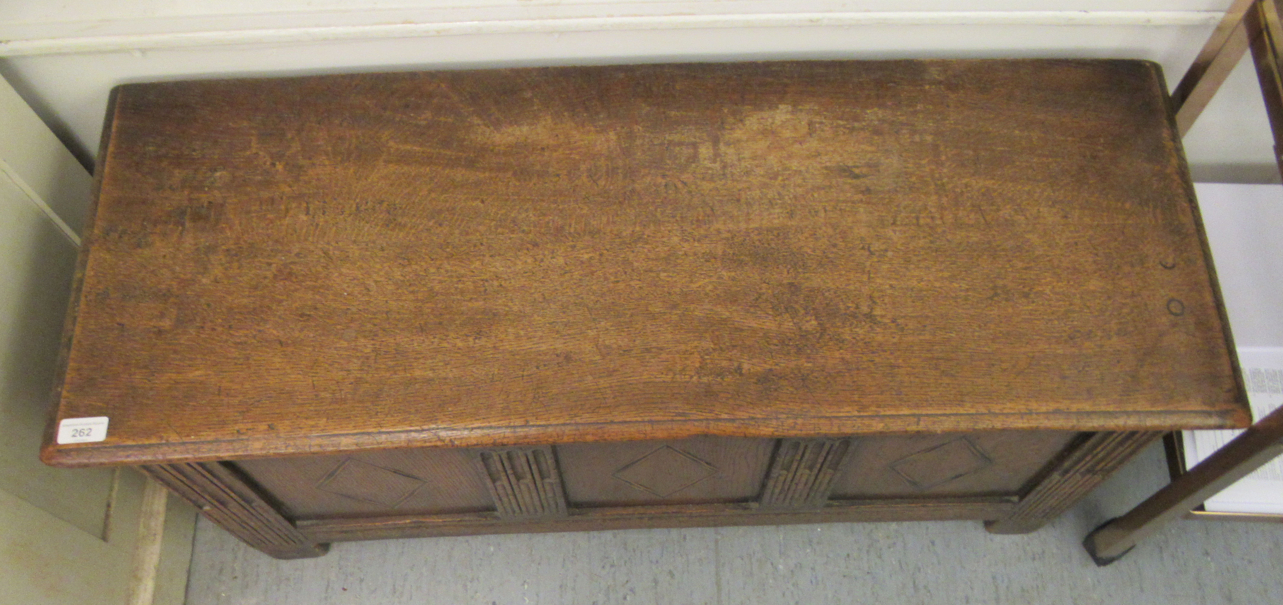 An early 20thC oak coffer with straight sides and a hinged lid, over a tri-panelled front, raised on - Image 2 of 3