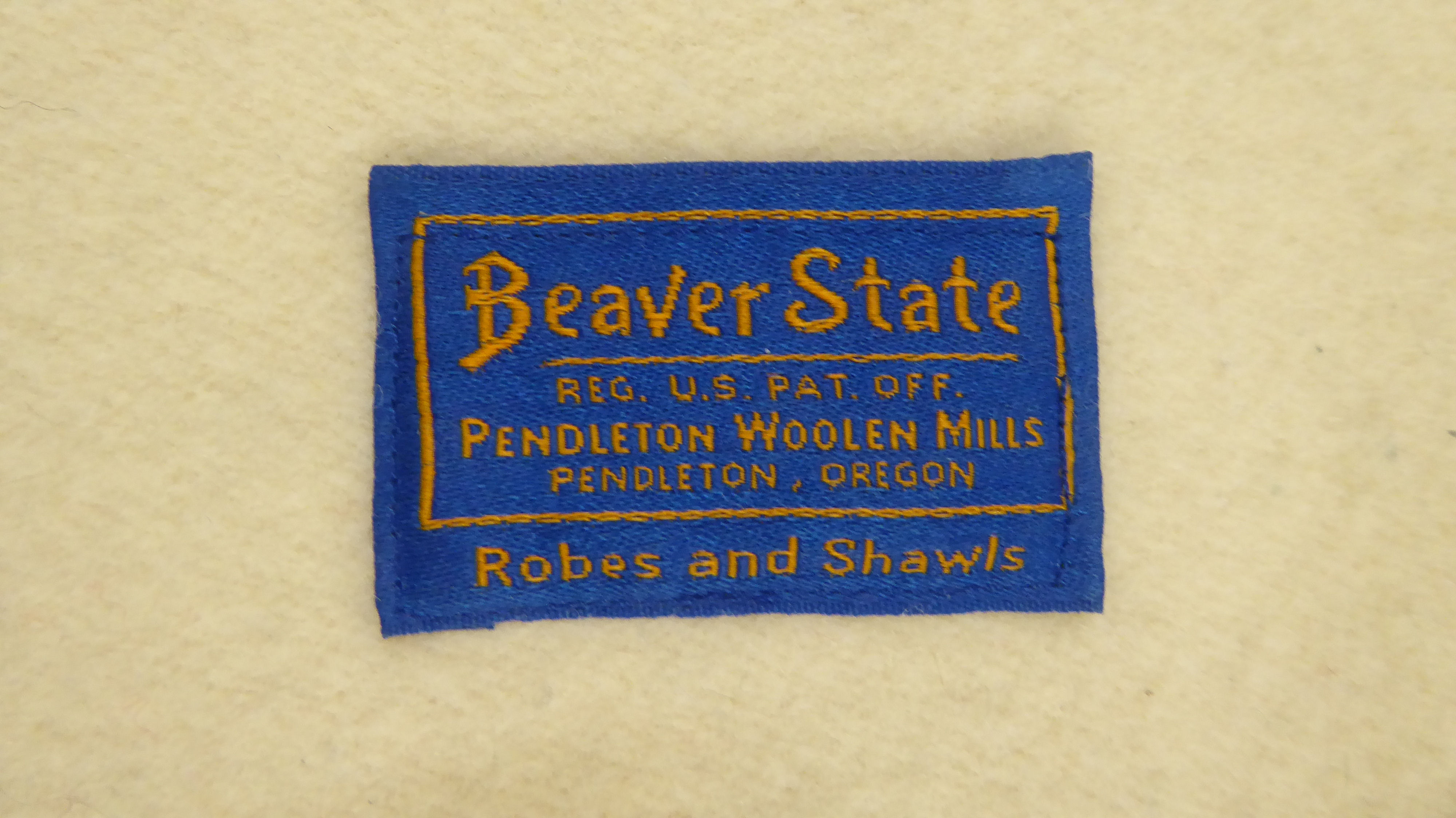 A Beaver State woollen throw/rug, highly decorated in orange and brown tones, on a cream coloured - Image 4 of 5