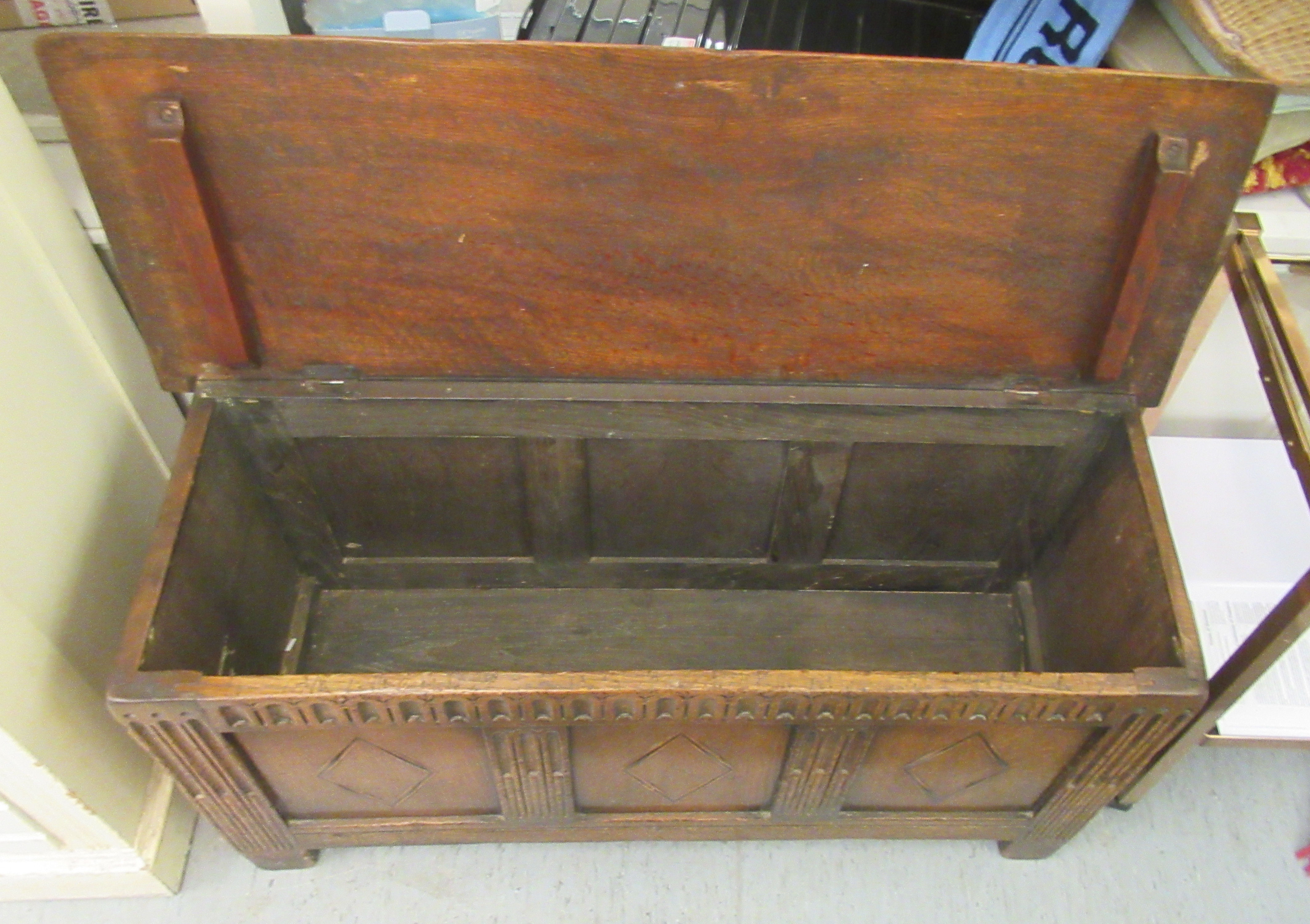 An early 20thC oak coffer with straight sides and a hinged lid, over a tri-panelled front, raised on - Image 3 of 3