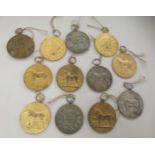 Twelve various, 1950s white and gilded metal, Continental, equestrian medallions