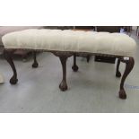 A modern Chippendale design mahogany window seat with a button upholstered top, raised on cabriole