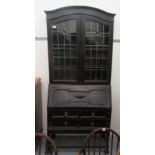 An Art Nouveau oak bureau bookcase, the upper section with a pair of lead glazed doors, over a