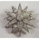 A gold coloured metal and diamond encrusted star design brooch