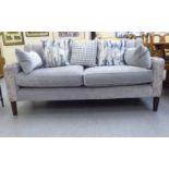 A modern Orior three person settee with a level back and swept, enclosed arms, upholstered in grey