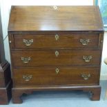 A 19thC country made honey coloured oak bureau, the fall flap enclosing a fitted interior, over twin