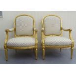 A pair of modern Louis XVI style antique finished gilded showwood framed open arm salon chairs,