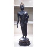 An Asian patinated bronze finished standing Buddhist figure, on a lotus flower plinth  26"h