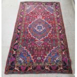 An Asfar rug, decorated with repeating stylised designs on a multi-coloured ground  48" x 81"