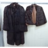 Dark brown fur, viz. a cape; and a 1940s style full length coat with fur covered buttons and wide
