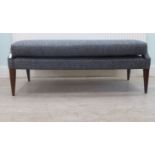 A modern blue fabric upholstered, cushioned, window seat, raised on square, tapered legs  55"w