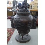 An Asian bronze covered, ovoid shape vase with a Dog of Fo finial, mythical beasts' heads, birds and