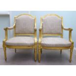 A pair of modern Louis XVI style antique finished gilded showwood framed open arm salon chairs,