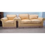 A modern two person settee, upholstered in peach coloured fabric with a tasselled trim, on block