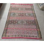 A Kelim rug, decorated in bright colours with a repeating design  61" x 91"