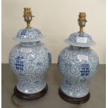 A pair of Oriental style china vase design table lamps, decorated in blue and white with floral
