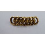 A yellow metal multi interlinked bar brooch