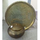 A Middle Eastern decoratively engraved pot of bulbous form with a swing handle and cover  12"h;