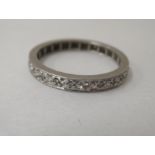 A white metal eternity ring, set with diamonds