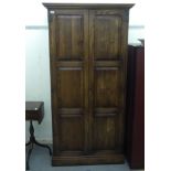 A modern rustic coloured oak wardrobe, the pair of tri-panelled doors, on iron butterfly hinges