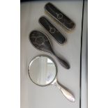 A four items silver backed and tortoiseshell dressing table set  comprising a hand mirror and