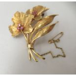 An 18ct gold brooch, fashioned as a bushel of leaves and set with six rubies
