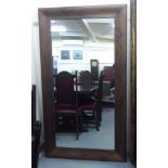 A modern dressing mirror, set in a wide, cushion moulded mahogany frame  71"h  39"w