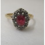 An 18ct gold cluster ring, set with a central ruby, surrounded by diamonds