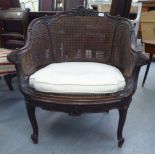 A late 19thC French stained beech framed bergere style salon chair with a double caned back,