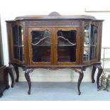 A late Victorian mahogany display cabinet with a low upstand, over a pair of central glazed doors