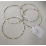 A series of four gold coloured metal bangles  bearing stamped marks