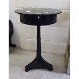 A Victorian style black lacquered pedestal table, the top painted with wild flowers, over a