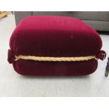 A modern maroon velvet effect fabric upholstered, square footstool with rope effect trim