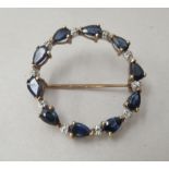 A 9ct gold brooch, fashioned as a ring, set with alternating sapphires and diamonds