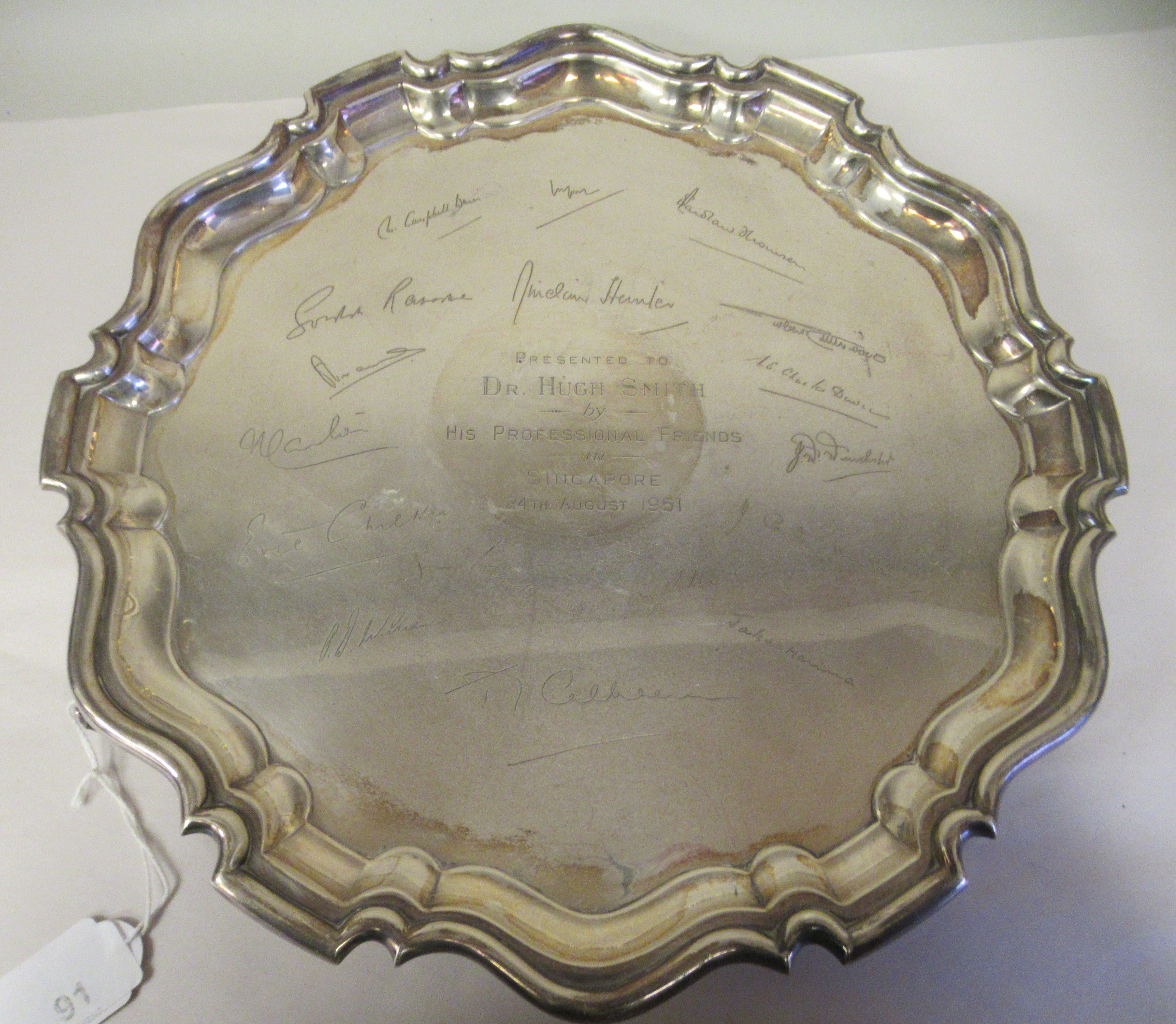 A Georgian style silver salver with a raised piecrust border, elevated on scrolled feet  S Ltd