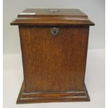An early 20thC stained oak desktop stationary box with a hinged top and lockable fall front,