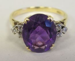An 18ct gold claw set amethyst and diamond ring