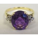 An 18ct gold claw set amethyst and diamond ring