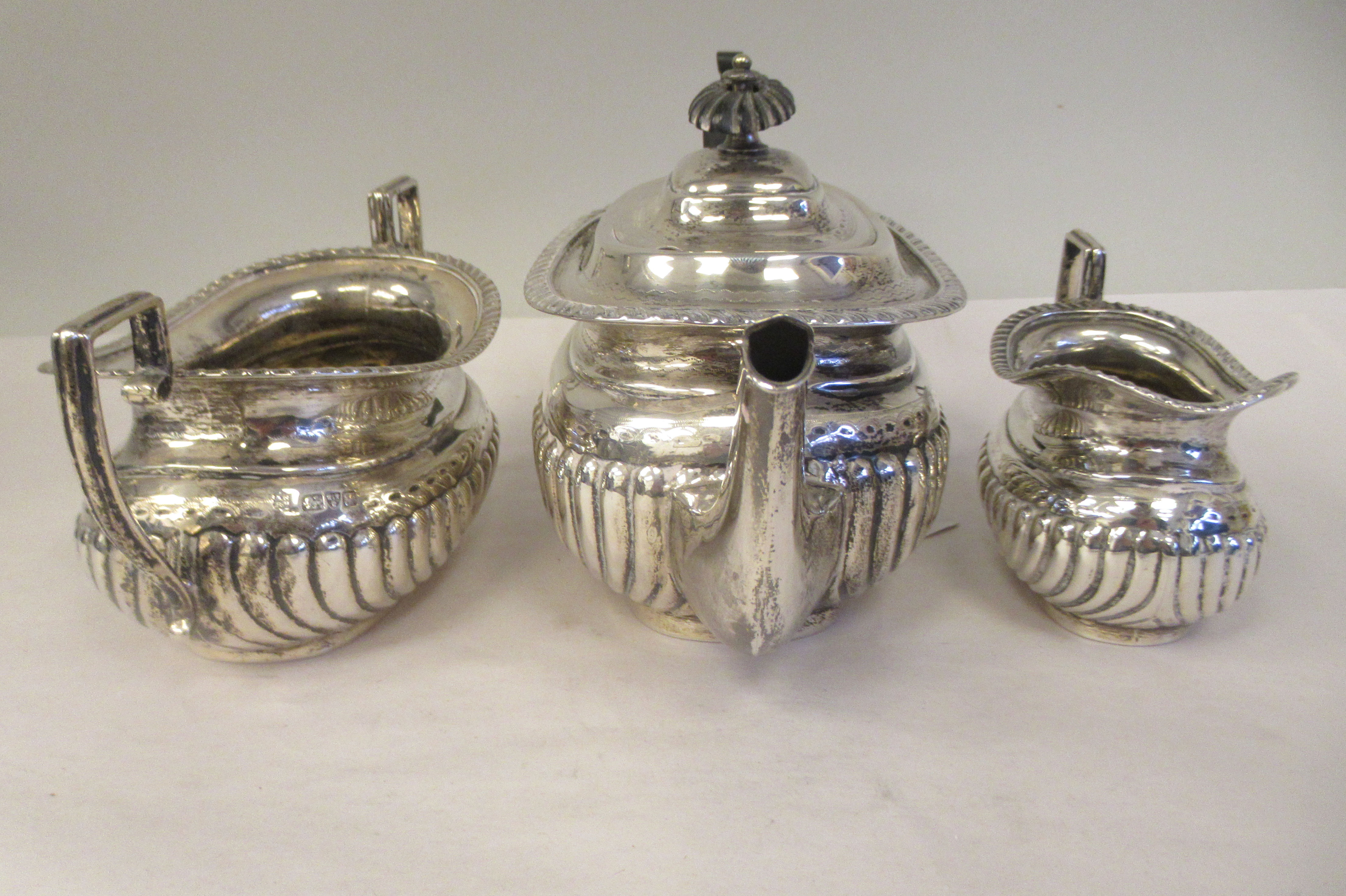 An Edwardian batchelor's three piece silver tea set of oval, ogee shape, demi-reeded form, - Image 5 of 9