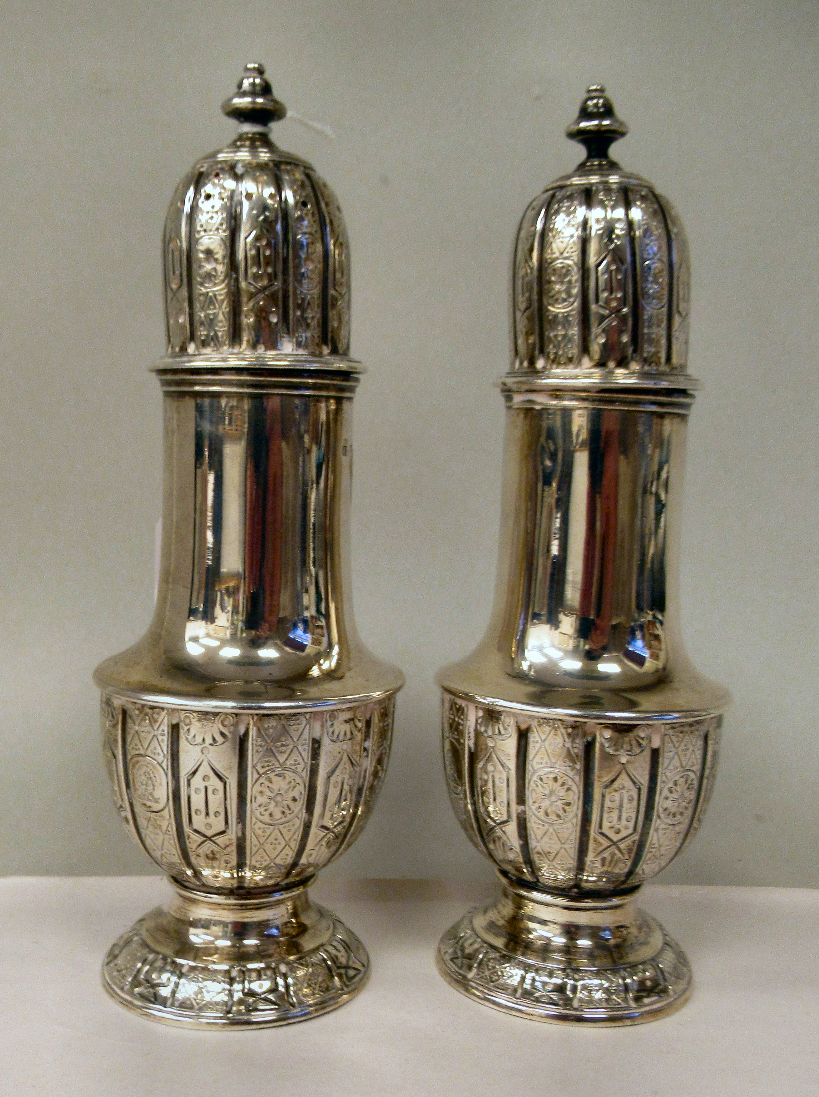 A pair of mid Victorian silver pedestal vase design condiments pots with uniformly engraved,