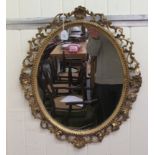 A 19thC oval mirror, the later plate set in a shell carved and foliate scrolled, giltwood frame  25"